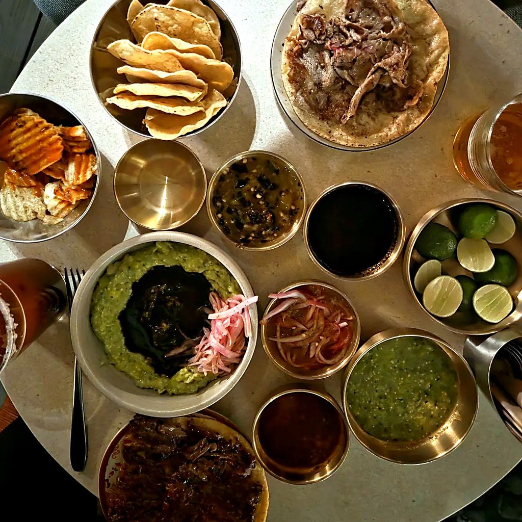 Table de tacos, salsas, chips et guacamole à La Once Mil, taquería de luxe de Roma Norte