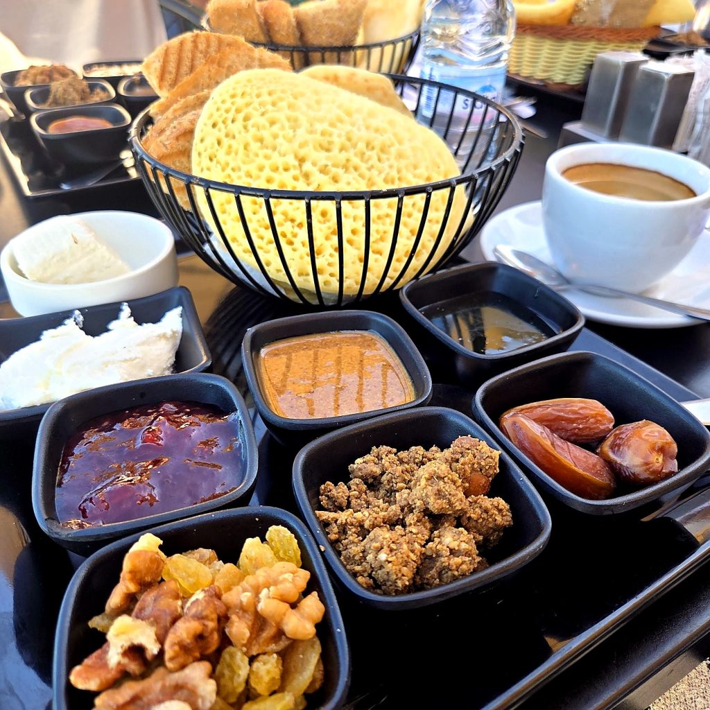 Petit-déjeuner marocain : baghrir, amlou, dattes, fruits secs et miel dans des petits bols